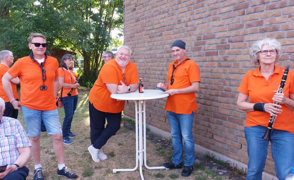 Konzertpause Sommerkonzert 2025 im Garten der Ev. Gemeinde Sinnersdorf, Orchestermitglieder am Stehtisch